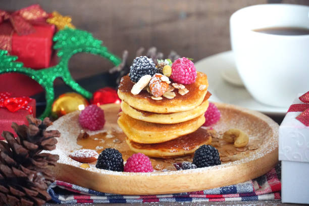 istock Pancake topping with berries and nut with background gift and pine cone under christmas tree, holiday party dessert. 1077515754