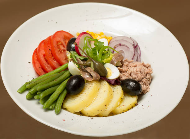 istock Tuna salad with vegetables,  placed on a white plate,  brown background 1077518050