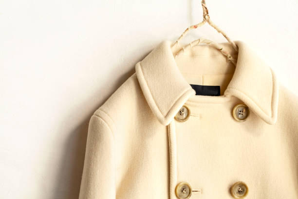 istock white wool coat hanging on clothes hanger on white background 1077520512