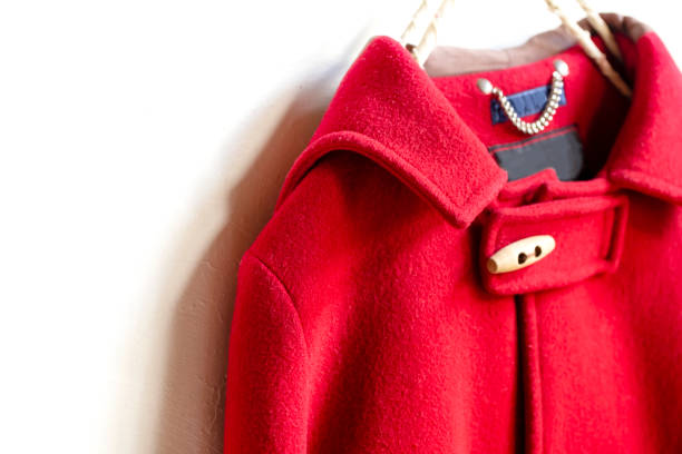 istock red wool coat hanging on clothes hanger on white background 1077520560