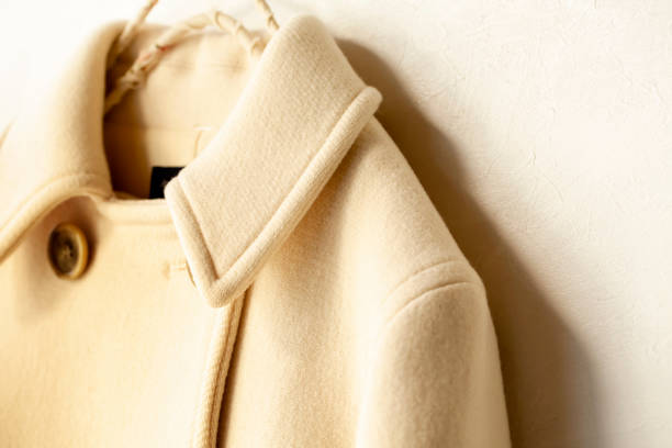 istock white wool coat hanging on clothes hanger on white background 1077520584