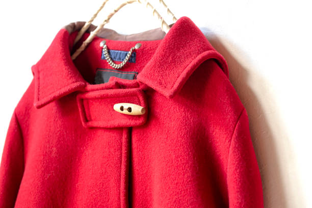 istock red wool coat hanging on clothes hanger on white background 1077520606