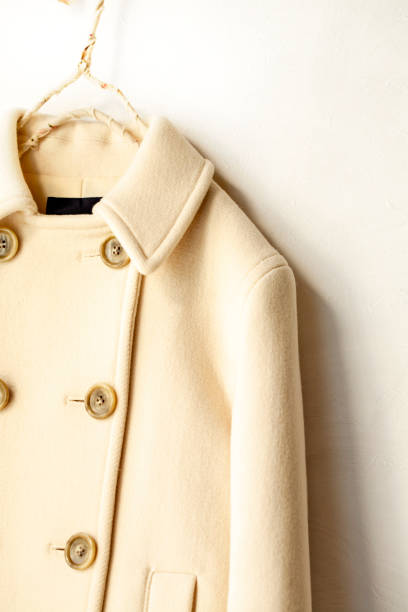 istock white wool coat hanging on clothes hanger on white background 1077520632