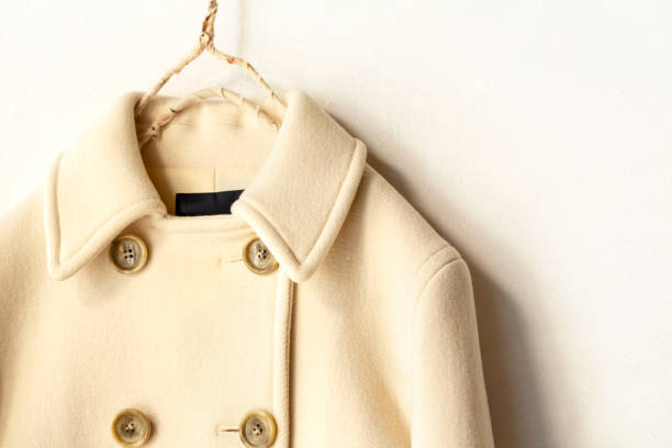 istock white wool coat hanging on clothes hanger on white background 1077520670