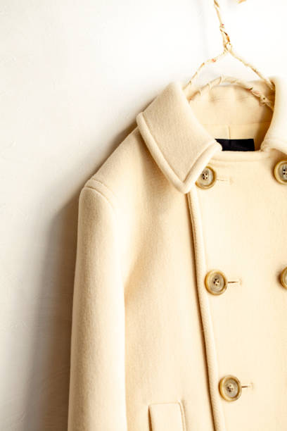 istock white wool coat hanging on clothes hanger on white background 1077520702
