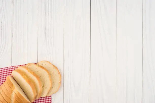 Photo of Loaf of bread on a wooden table. Top view.