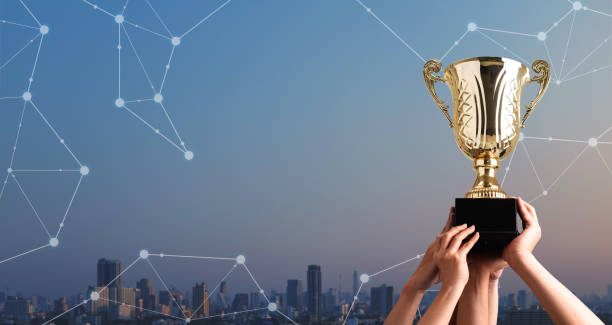 istock Winning team raise trophy cup with digital background, digital achievement conceptual 1077521410