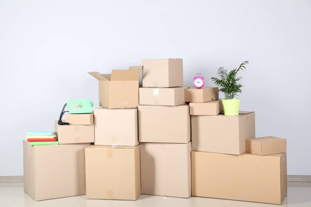 istock Cardboard boxes with household stuff on gray background 1077523212