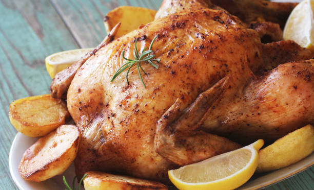 istock Whole roasted chicken with potatoes and lemon 1077523618