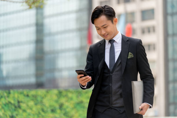 istock Young businessman using his phone outdoors 1077524022