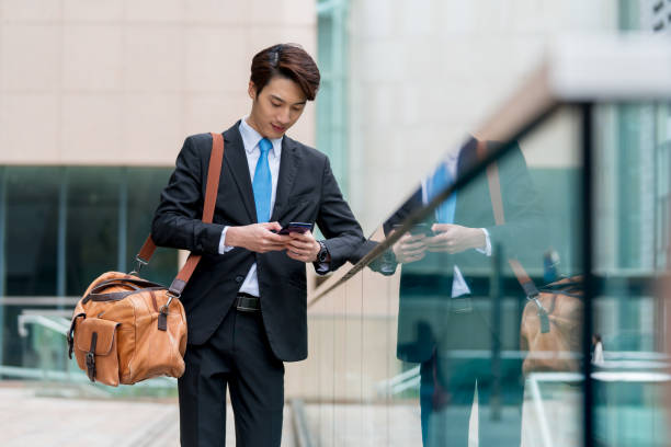 istock Young businessman using his phone outdoors 1077524118