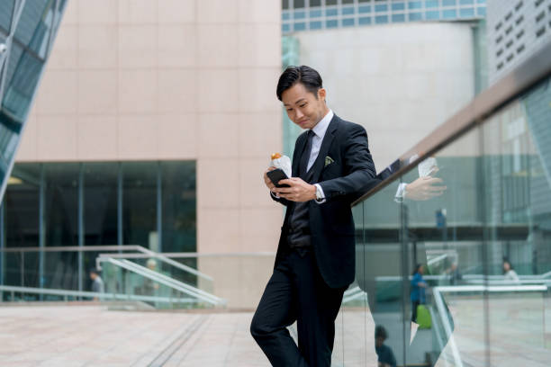 istock Young businessman on his lunch break using his phone outdoors 1077524170