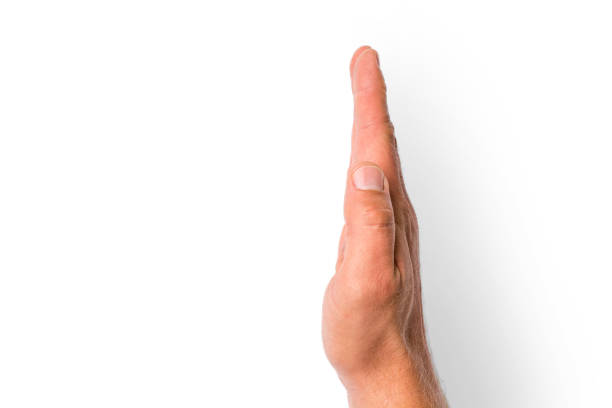 Shadow of a hand from the night light of a flashlight on a white wall. Dark silhouette of a man hands from the light of a lamp