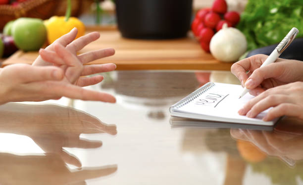 istock Closeup of human hands discussing something while cooking in kitchen. Women talking about menu. Family dinner, friendship and lifestyle concept. 1077531518