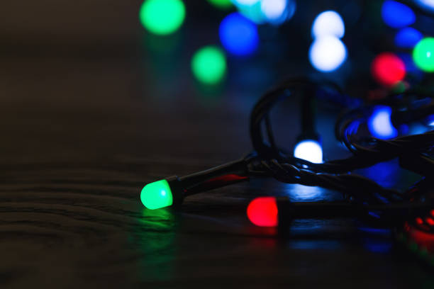 istock Christmas lights on dark wooden background with copy space 1077533152