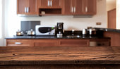 istock Wooden table in front of defocused modern kitchen counter top 1077538268
