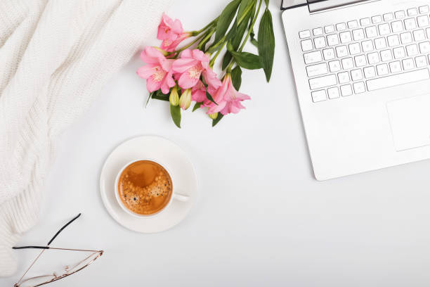 istock Coffee, flowers and laptop on the white table 1077538362