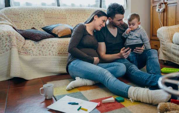 rodzina z dzieckiem i ciężarną matką patrzącą na tabletkę - ipad baby boys little boys caucasian zdjęcia i obrazy z banku zdjęć