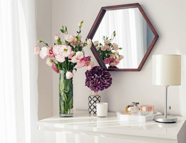 Modern interior details. Light room with mirrow, flowers, night lamp and other objects
