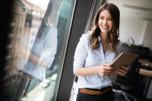 istock Attractive businesswoman using a digital tablet while standing in front of windows 1077547102