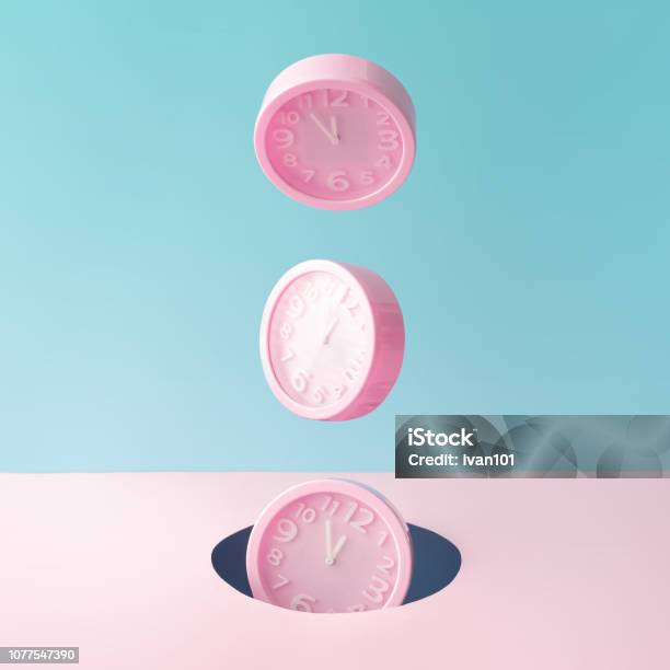 Pastel Pink Wall Clocks On Blue Backdrop Falling Down Stock Photo - Download Image Now