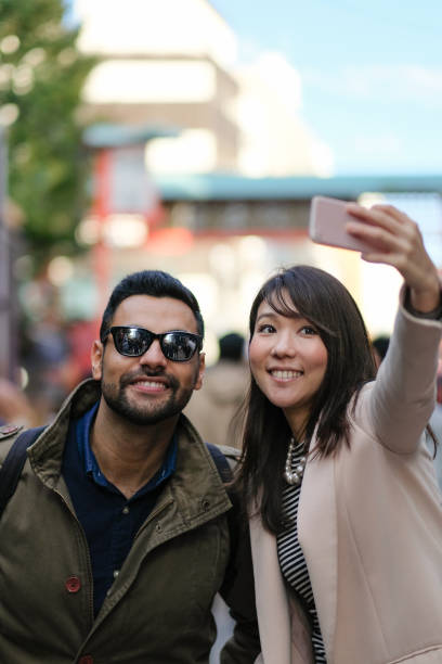 pareja tomando selfie en turismo en tokio - japanese culture japan japanese ethnicity asian and indian ethnicities fotografías e imágenes de stock