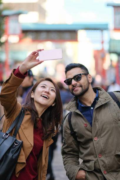 woman and man taking selfie in tourist spot in tokyo - japanese culture japan japanese ethnicity asian and indian ethnicities imagens e fotografias de stock