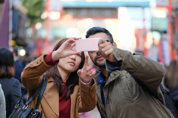 woman and man taking selfie in tourist spot in tokyo - japanese culture japan japanese ethnicity asian and indian ethnicities imagens e fotografias de stock