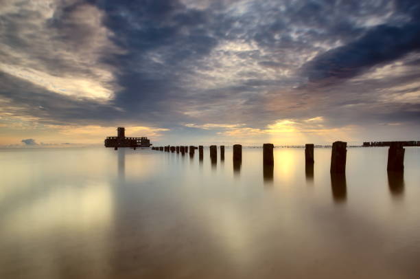 istock Remains of a pier in the sunrise light. 1077556584