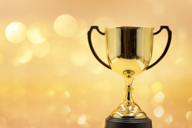 istock trophy over wooden table and dark background bokeh. 1077557282