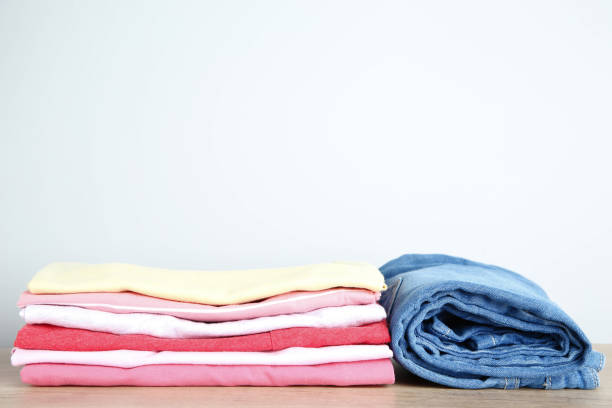 istock Stack of folded clothes with jeans on wooden table 1077557630