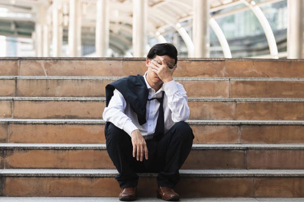 istock Unemployed stressed young Asian business man suffering from severe depression. Failure and layoff concept. 1077561512