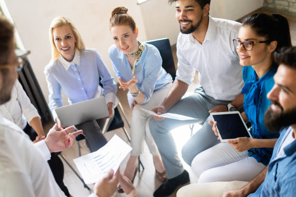istock Happy designer people working together at desk on computer in office 1077565560