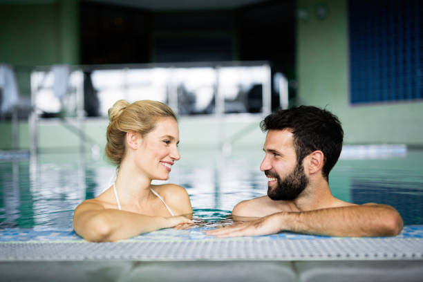 istock Happy attractive couple relaxing in swimming pool 1077574408