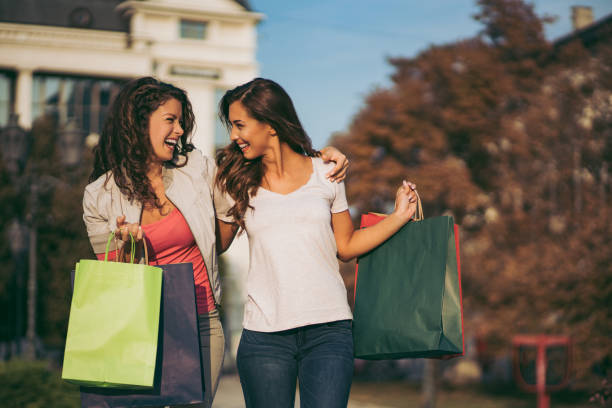 istock Two beautiful women taking a walk after shopping 1077580640