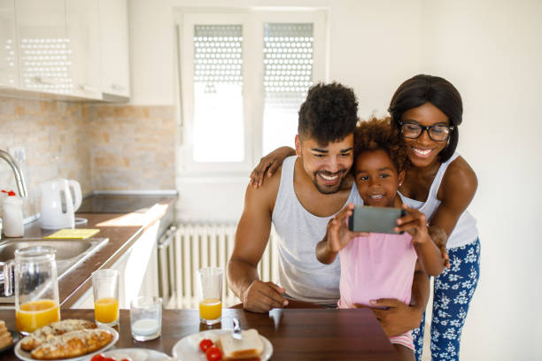 istock Cheerful family taking Selfie during breakfast 1077583390