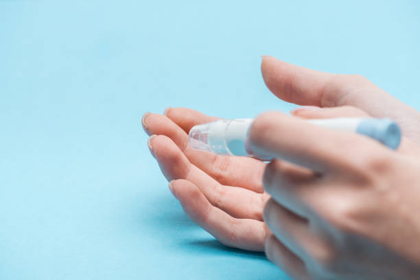 istock cropped view of female hands testing glucose level with needle on blue background 1077583740