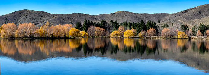 Panorama with autumn reflections in Kellands Pond near Twizel, South Island New Zealand, May 2018