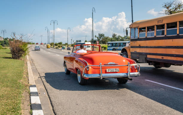 voiture classique colorée sur une route avec un bus de la havane - cuba car chevrolet havana photos et images de collection