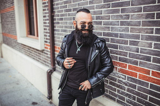 Happy bearded biker standing on the street