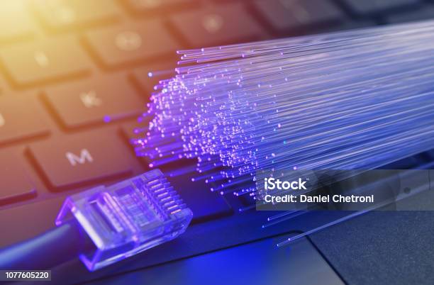 Fiber Optics In Blue Close Up With Ethernet And Keyboard Background Warm Lens Flare Stock Photo - Download Image Now