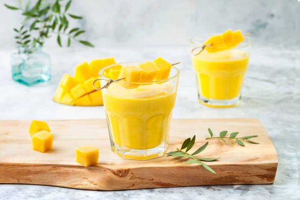 Mango Lassi, yogurt or smoothie with turmeric. Healthy probiotic Indian cold summer drink stock photo