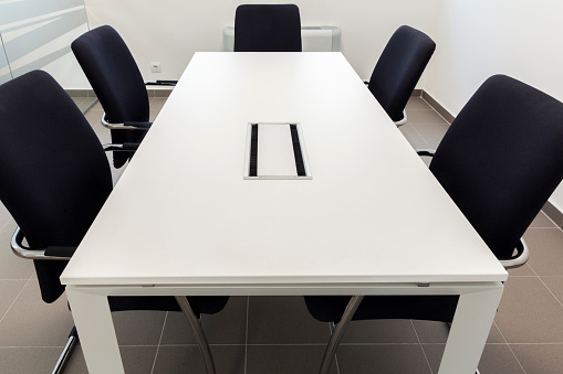 small conference room, white table and black chairs