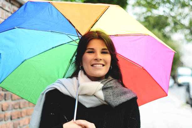 istock Beautiful woman under rainbow umbrella 1077633410