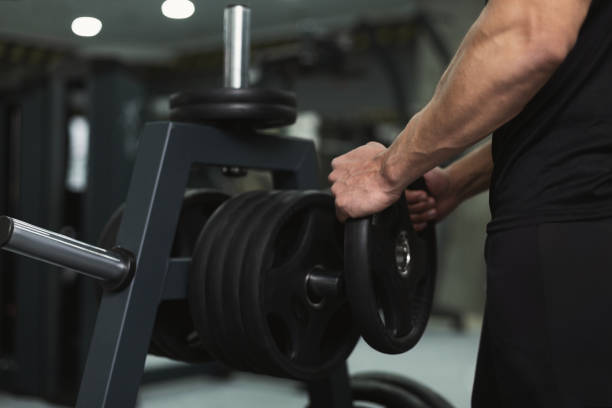 istock Muscular man bodybuilder picking up heavy dumbbell 1077639314