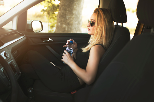 woman drinking water from car