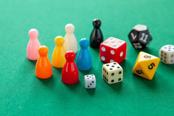 istock Colored game figures chips for board games. Collection of dice cubes on green table 1077645696
