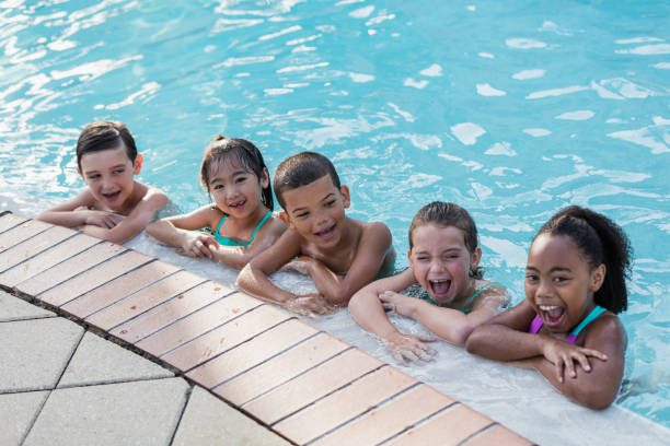 istock Five multi-ethnic children having fun in swimming pool 1077646036