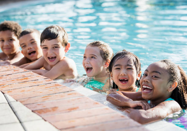 istock Multi-ethnic group of children on side of swimming pool 1077647344