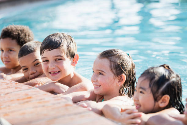 istock Boy with friends in swimming pool 1077647676